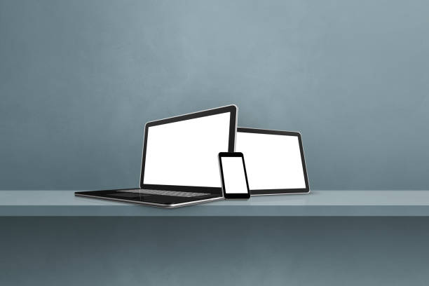 istock Laptop, mobile phone and digital tablet pc on grey wall shelf. Horizontal background 1356512812