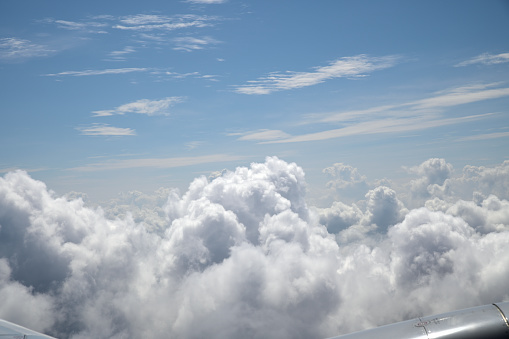 Clouds visible from the airplane window. Airplane above the clouds.