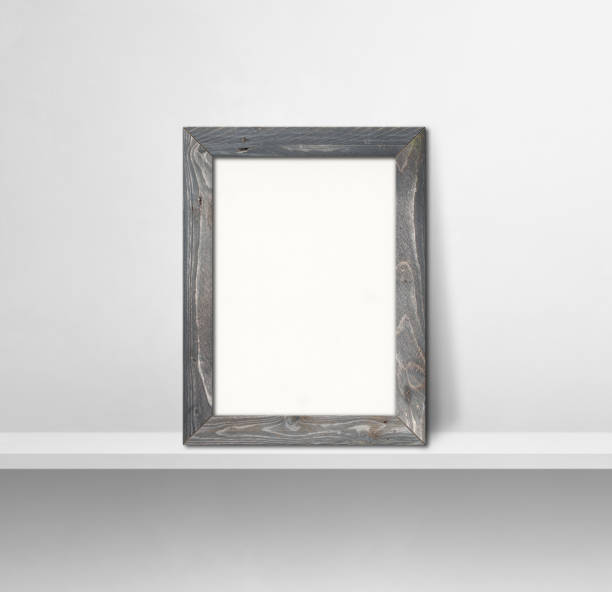 istock Wooden picture frame leaning on a white shelf. 3d illustration. Square background 1356513132