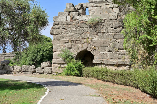 istock Fragment of a dilapidated ancient wall with a passage. Stone blocks are scattered around 1356513209
