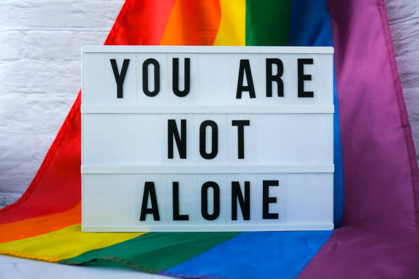 istock Rainbow flag with lightbox and text YOU ARE NOT ALONE. Rainbow lgbtq flag made from silk material. Symbol of LGBTQ pride month. Equal rights. Peace and freedom 1356513497