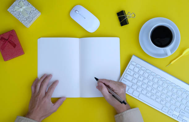 istock Man hands working on notebook and pen on a desk in an office, working space 1356514548