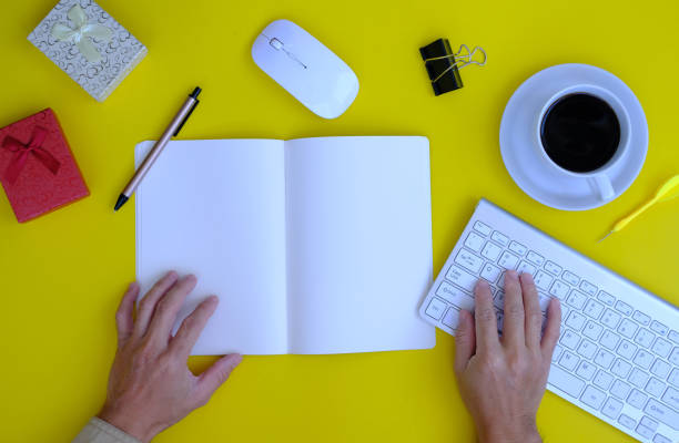 istock Man hands working on notebook and pen on a desk in an office, working space 1356514552