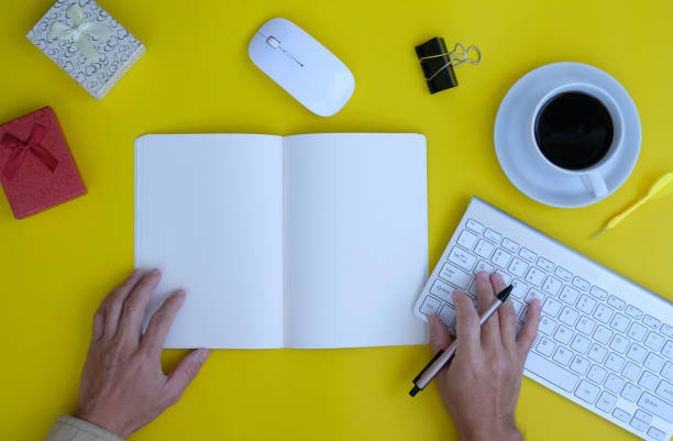 istock Man hands working on notebook and pen on a desk in an office, working space 1356514554