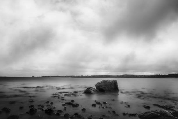 istock Large rock in the silky smooth water 1356515781