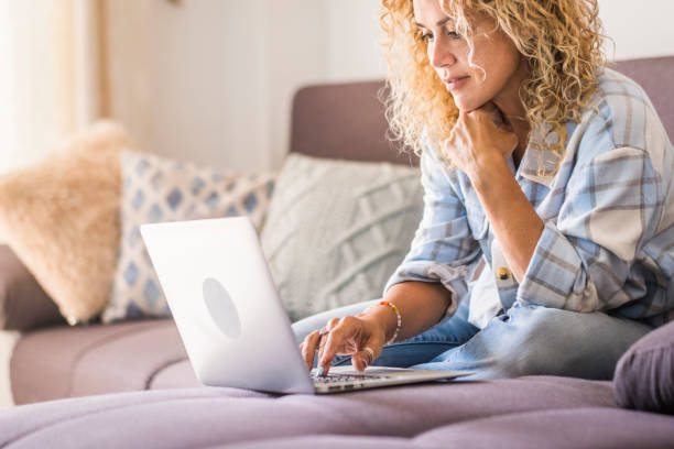 istock Midsection Of Woman Using Mobile Phone While Sitting On Sofa At Home 1356521078