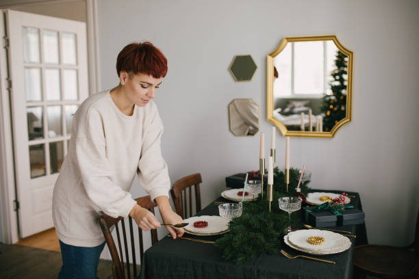 istock Young woman serving Christmas table with beautiful festive tableware. Preparations for holiday dinner. 1356521685