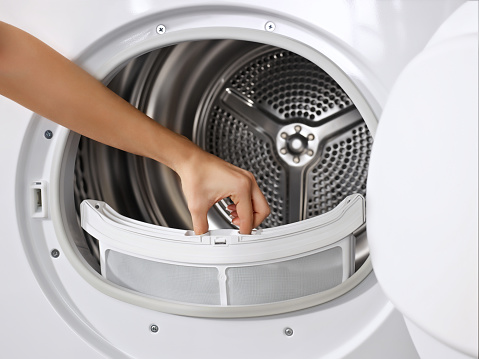 Woman cleaning dryer’s filter