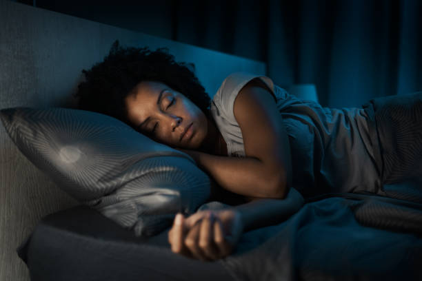 afroamerykanka śpiąca w swoim łóżku - snow house color image horizontal zdjęcia i obrazy z banku zdjęć