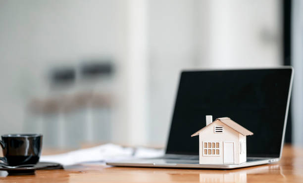 istock House model on laptop computer on wooden table with copy space, real estate concept. 1356525130