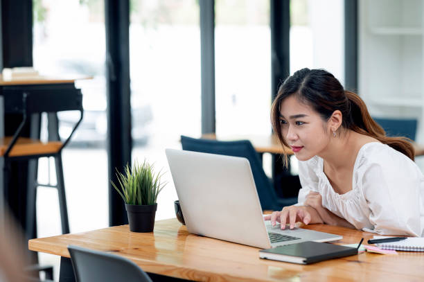 istock woman using laptop and look at the screen with attentively. 1356525148
