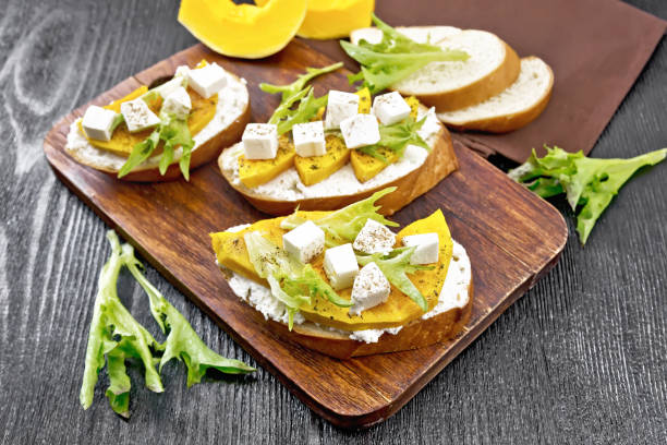 istock Bruschetta with pumpkin and arugula on dark board 1356525168