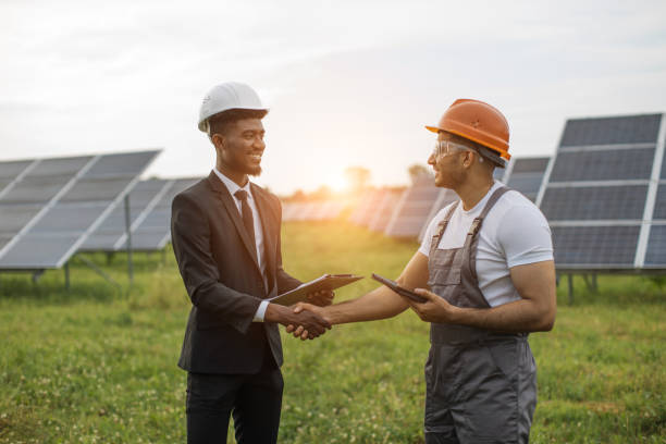 inspector e ingeniero dándose la mano entre la planta solar - hardhat construction men handshake fotografías e imágenes de stock