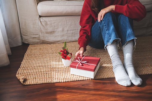 Closeup image of a woman holding a red present box