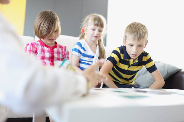 istock Kids sitting on sofa and play card game together for development 1356529235