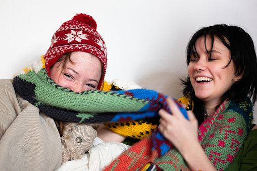 cheerful teenage girls have fun in a mountain of clothes
