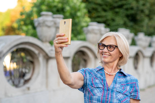 istock Beautiful senior woman taking a selfie 1356537795
