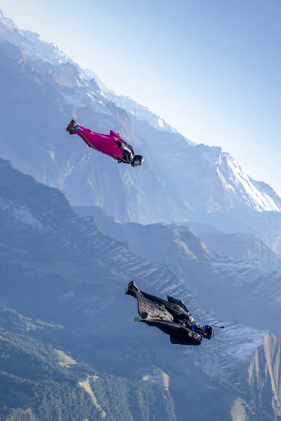 istock Friends in wingsuits glide through clear skies 1356537939