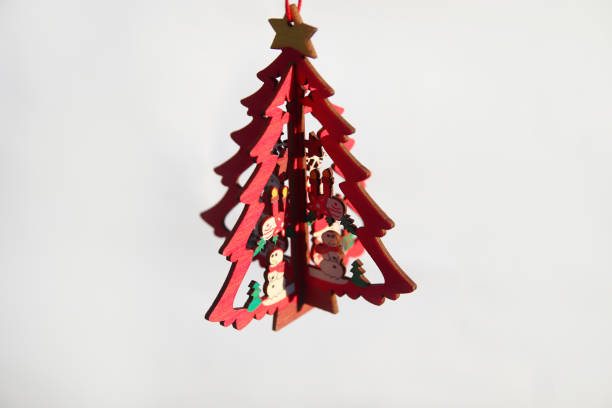 istock Christmas tree toy. Wooden small model winter pine tree wit yellow star isolated on white background. Christmas tree hanging. Festive card. Copy space. Dark shadow 1356539365