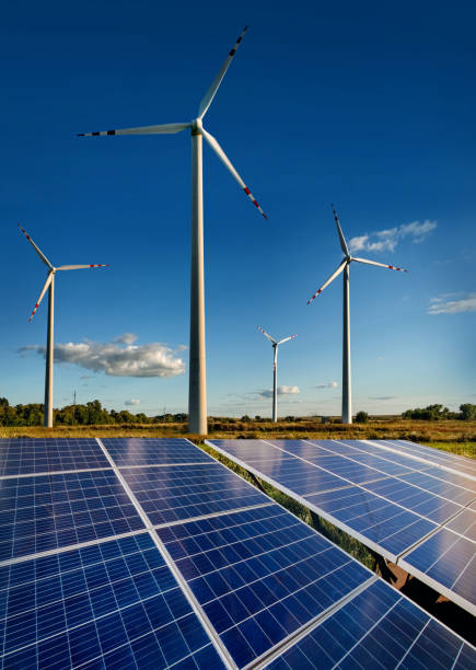 Wind turbines and solar panels closeup on sky background
