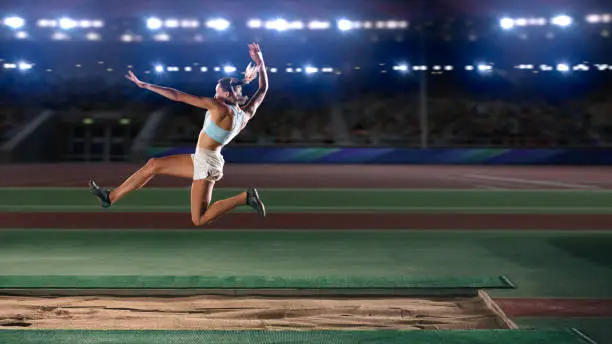 Photo of Long Jump Championship: Professional Female Athlete Jumping on Long Distance. Determination, Motivation, Inspiration of a Successful Sports Woman Setting New Record Result. Competition on Big Stadium.