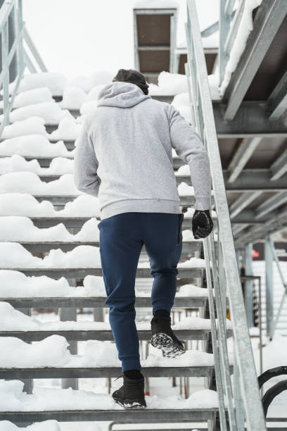 istock Athletic man running on stairs during his winter workout 1356540705