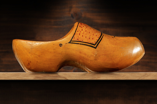 Close-up of a wooden clog made in Netherlands, above a wooden shelf with copy space. Photography.