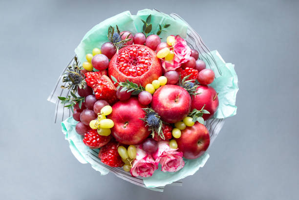 bouquet commestibile di frutta e fiori su sfondo grigio - gift apple ribbon fruit foto e immagini stock