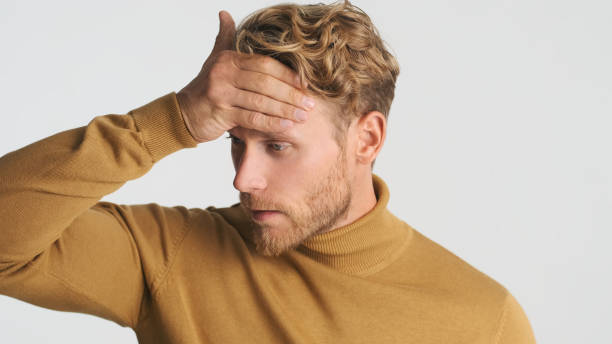 istock Portrait of young tired blond bearded man checking temperature feeling sick isolated on white background 1356543002
