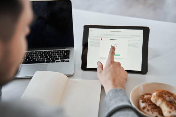 istock Man touching to the tablet screen with his finger while signing the document online 1356543239