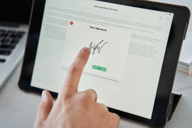 istock Man touching to the tablet screen with his finger while signing the document online 1356543241