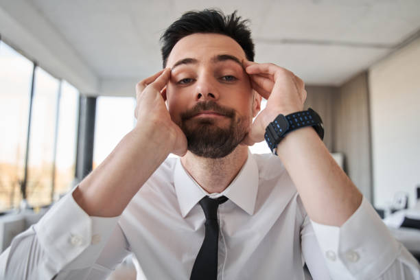 istock Entrepreneur in formal clothes looking at the camera with his head in his hands 1356543250