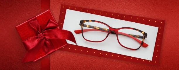 istock glasses merry christmas gift card, red package box with shiny ribbon bow, red spetacles isolated on white ticket , top view, layout useful as gift or pricing card or greeting card 1356543343