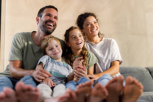 istock Cheerful family relaxing on sofa at home. 1356544321