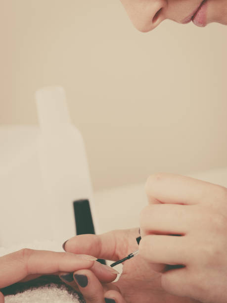 istock Woman in beauty salon getting manicure done. 1356545423
