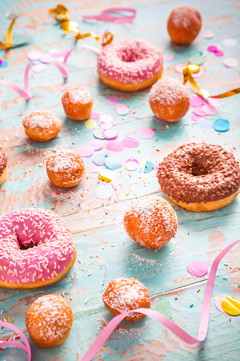 Krapfen, Berliner and donuts with streamers and confetti. Colorful carnival, birthday and Fasching image