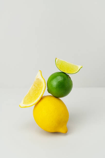 istock Fresh bright yellow lemon, green juicy lime slice balanced on grey background. Ripe citrus fruits on top of each other. Healthy food with vitamin C. Ingredients for lemonade. Minimal composition 1356546391