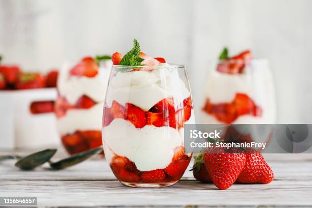 Healthy Breakfast Of Strawberry Parfait Made With Fresh Fruit And Yogurt Over A Rustic White Table Stock Photo - Download Image Now