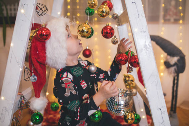 istock Toddler boy playing with Christmas ornaments 1356547577