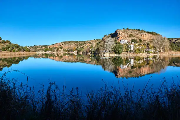 Landscape - Scenery of the surrounding mountains reflecting in the Laguna San Pedro - St Peter Lake, in the Lagunas de Ruidera Lakes Natural Park, UNESCO Biosphere Reserve, Albacete province, Castilla La Mancha, Spain, Europe