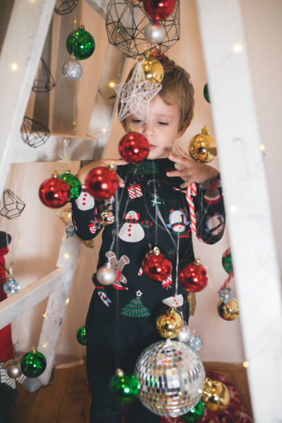 istock Toddler boy playing with Christmas ornaments 1356548729