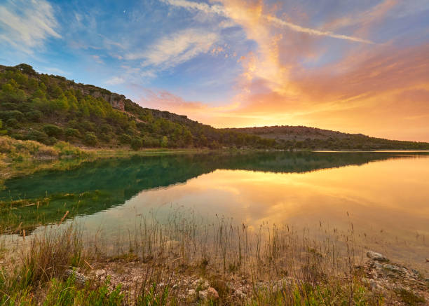 zachód słońca nad jeziorem laguna lengua - tongue, ze światłem słonecznym barwiącym chmury, w parku przyrody jezior lagunas de ruidera, hiszpania - tongue mountain zdjęcia i obrazy z banku zdjęć