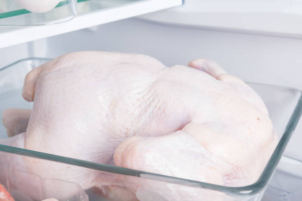 primer plano de un pollo entero, sobre el fondo de un refrigerador blanco, en un sustrato de vidrio - pavo ave de corral fotografías e imágenes de stock