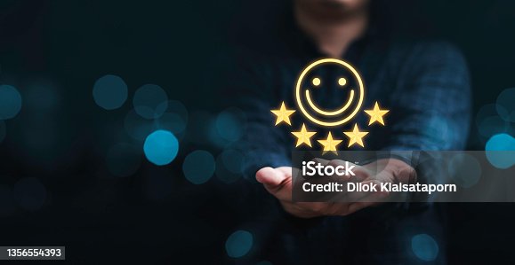 istock Businessman holding smile icon for the best evaluation , customer satisfaction concept. 1356554393