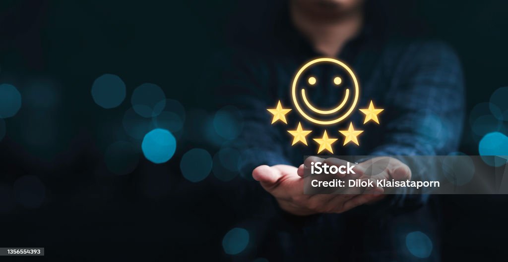 Businessman holding smile icon for the best evaluation , customer satisfaction concept. Customer Stock Photo