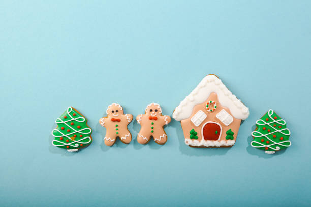 istock Christmas concept flat lay with gingerbread men and house on blue surface 1356554600