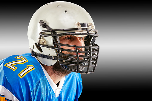 Players. Group of young sportive men, professional american football players in sports uniform and equipment posing isolated on white background. Concept of sport, competition, achievements, action