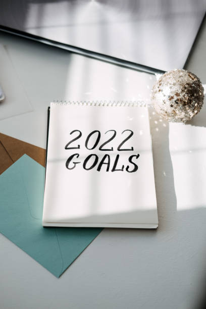 istock 2022 goals, New year resolution. Text 2022 goals in open notepad on the table. Start new year, planning and setting goals for the next year 1356556927