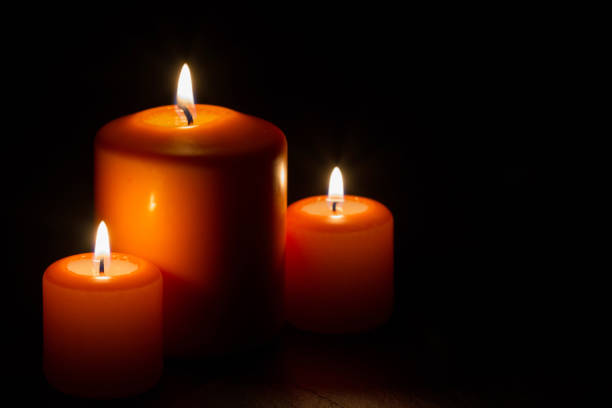 Composition of three burning candles on dark background concept