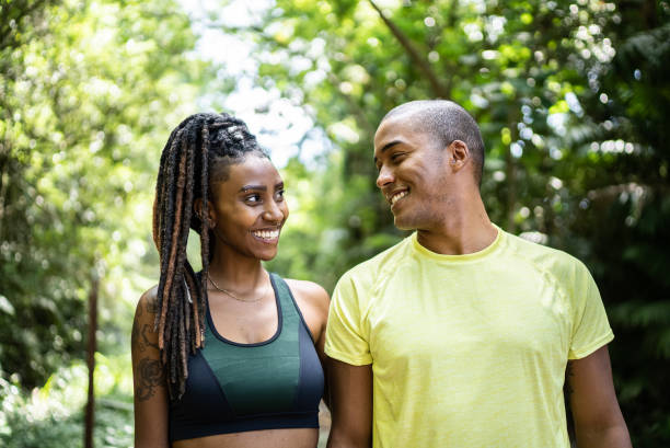 istock Happy friends looking at each other in a trail 1356557780